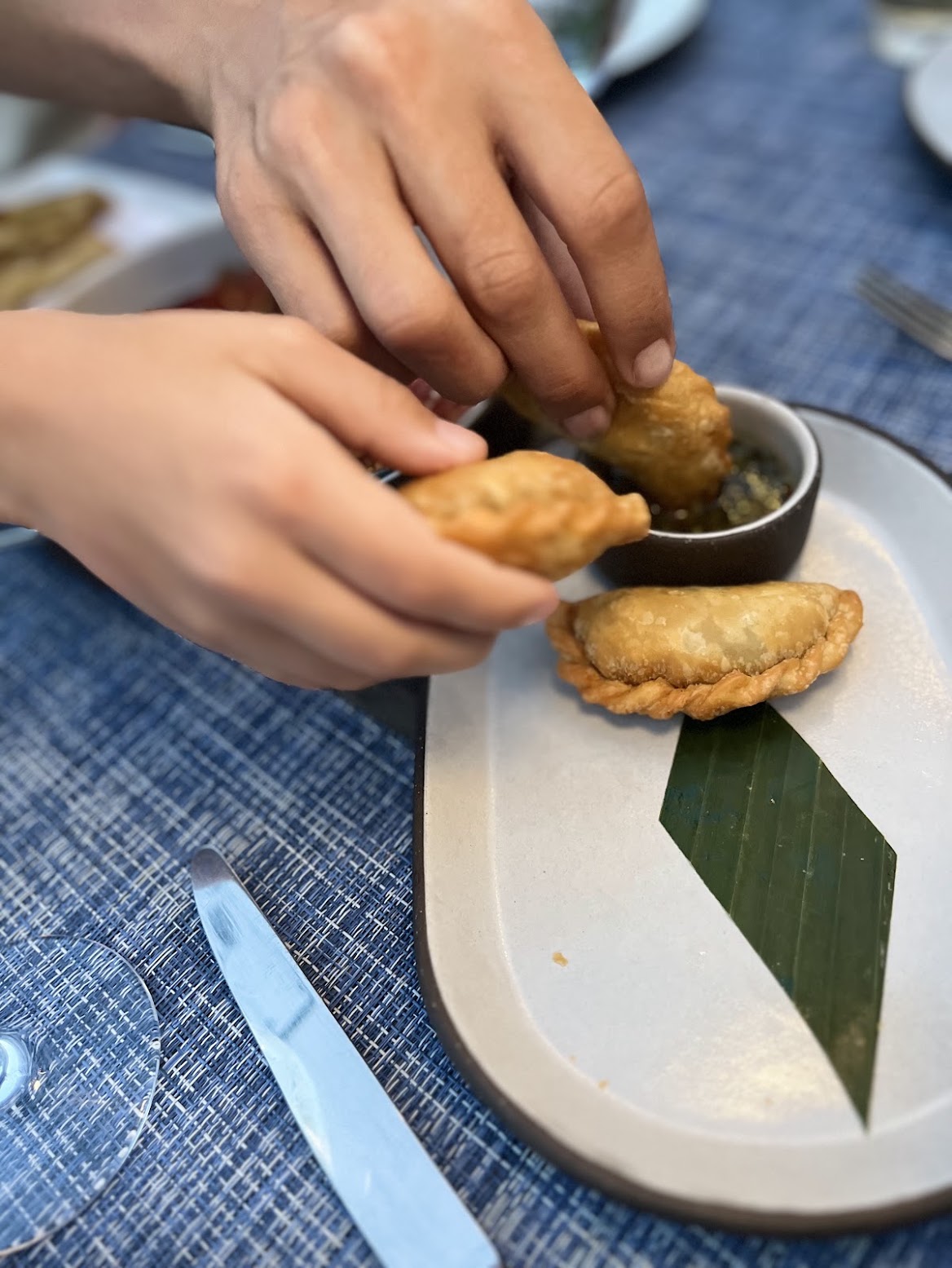 Two guests sharing Nicholson Muir empanadas with chimichurri